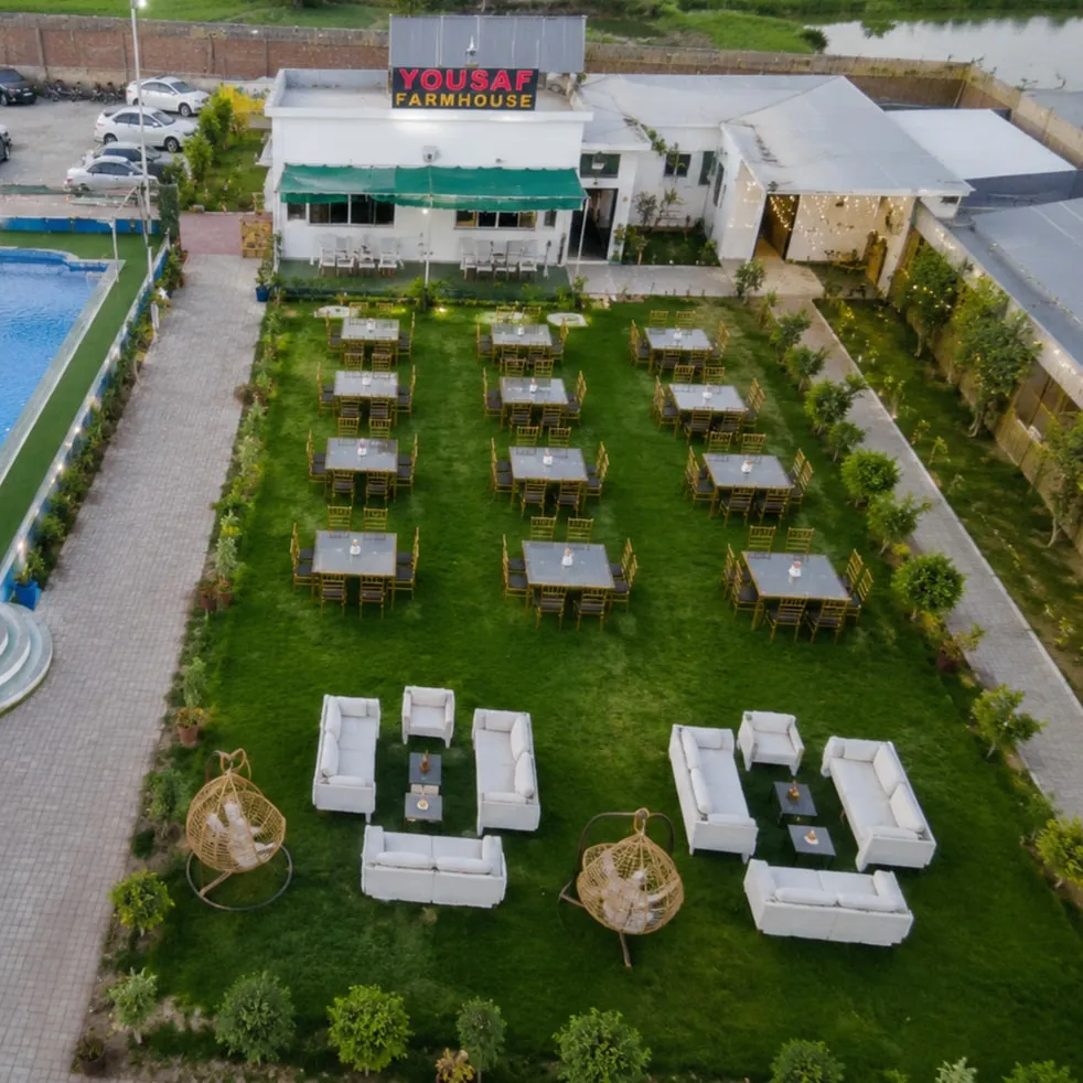The lawn at Yousaf Farmhouse set up with dining tables and lounge seating for a function