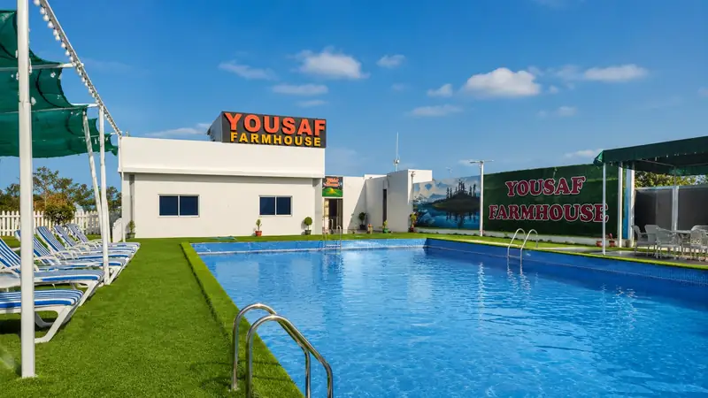 The family swimming pool and sun loungers at Yousaf Farmhouse, Faisalabad, on a clear day